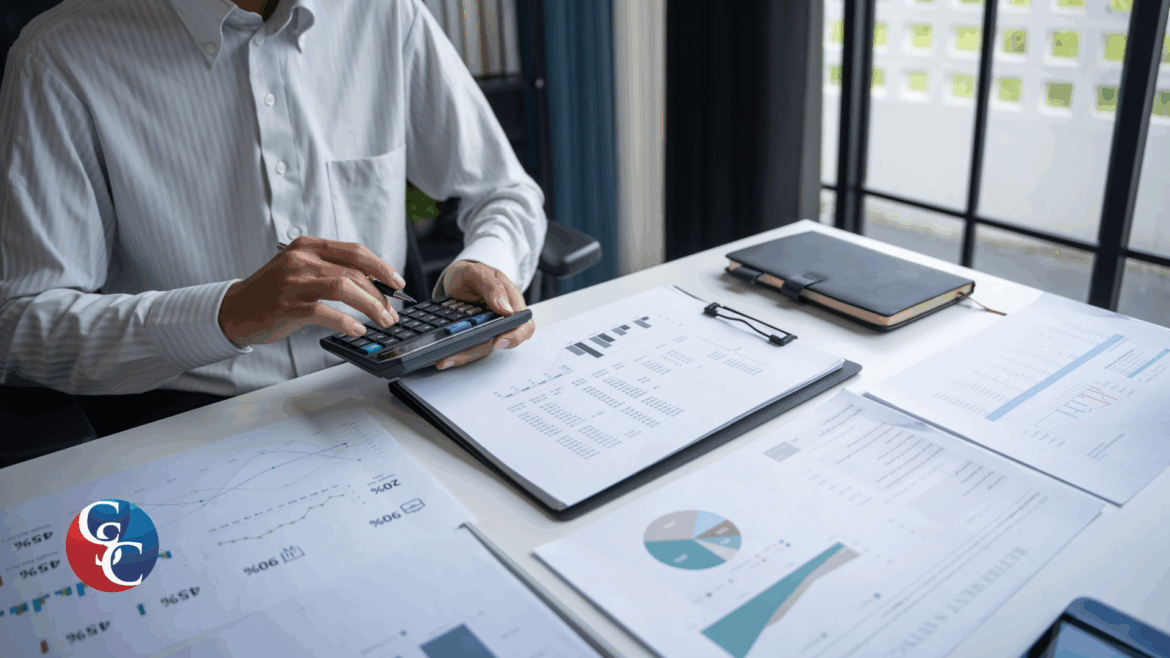 A businessman in a professional setting using a calculator and reviewing financial spreadsheets and charts. The image represents the due diligence and capital calculation process for a business acquisition funded by a hard money loan.