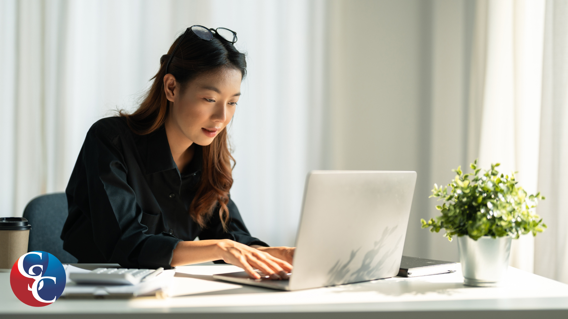 Female business owner reviewing documents in an office laptop.