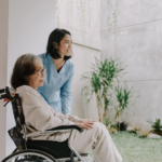 A caregiver assisting a senior patient in a wheelchair at home, symbolizing dedicated patient care during home health billing cycles.